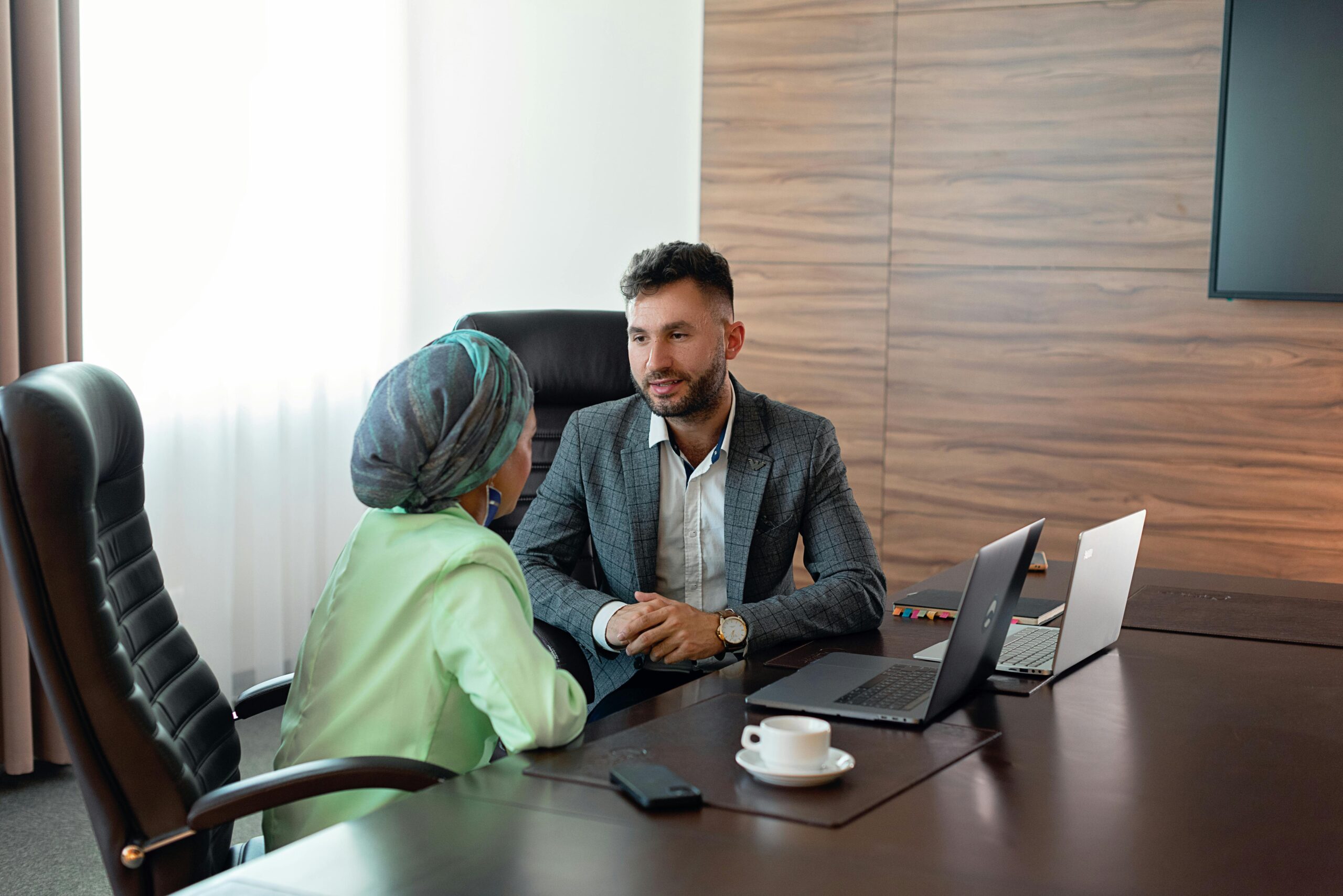 Two business colleagues discuss strategies during an office meeting, fostering teamwork.